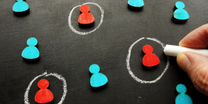 hand selecting a target customer icon representing audience targeting in marketing